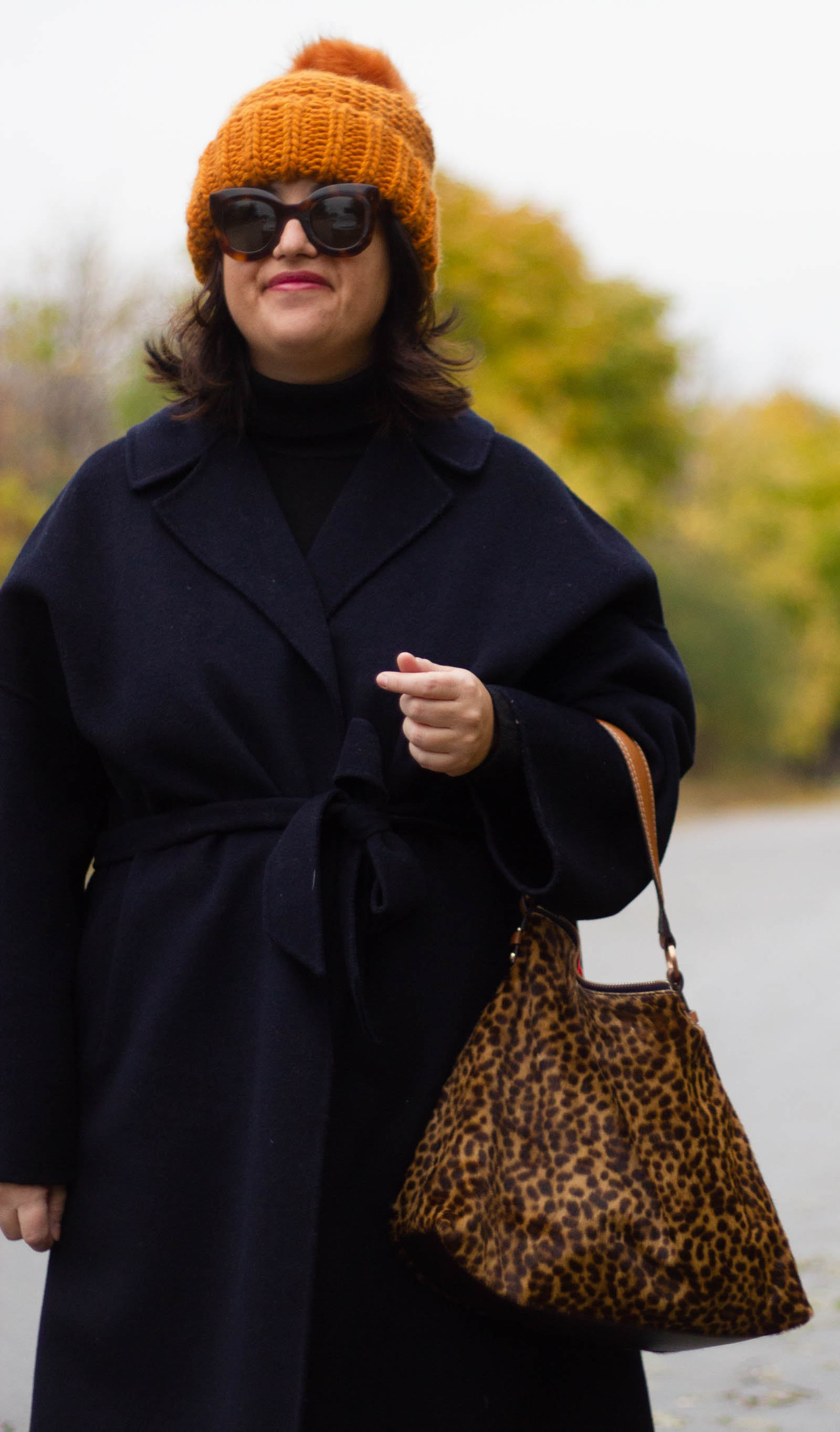 navy wrap coat, leopard bag and burnt orange hat