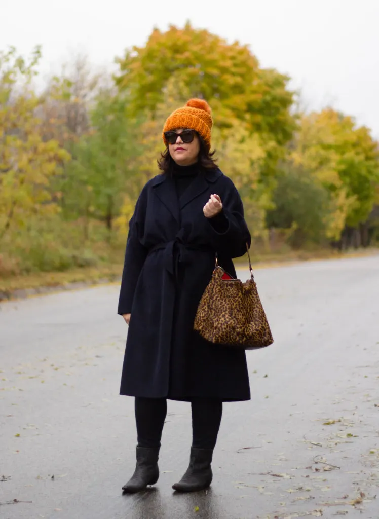 navy wrap coat, black turtleneck, leopard bag, burnt orange hat