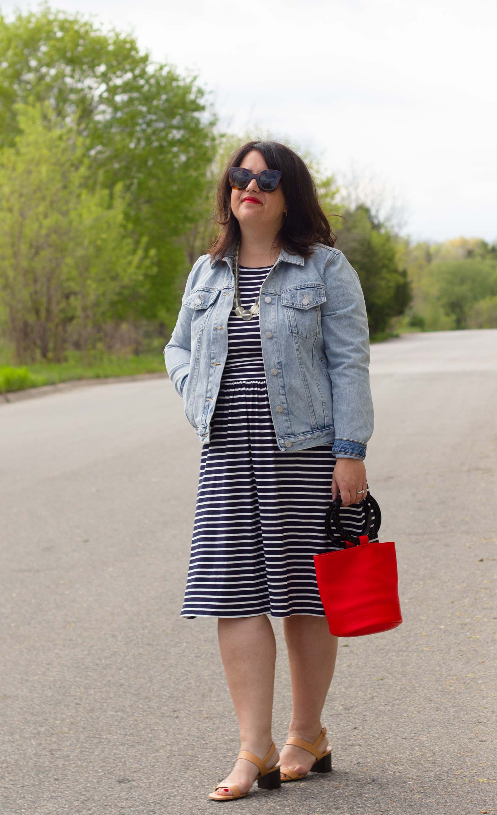 stripe dress worn with jean jacket and red bucket purse, neutral everlane two strap sandal