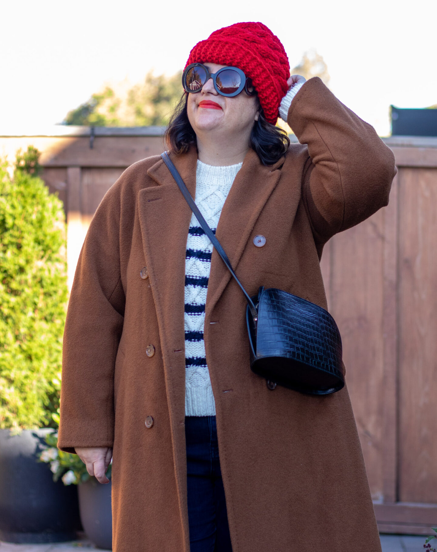 camel coat, stripe sweater, red hat