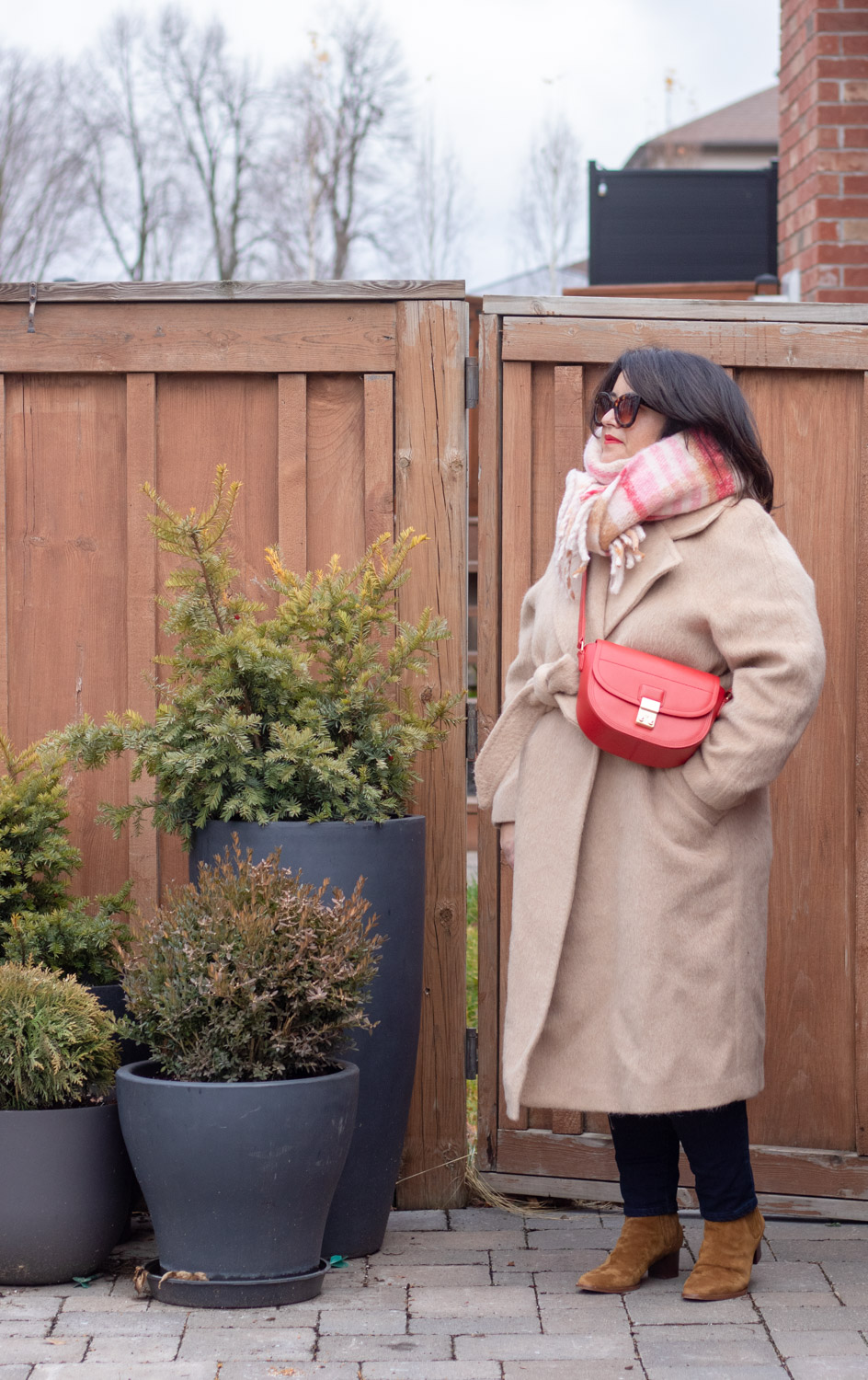 camel coat, red bag