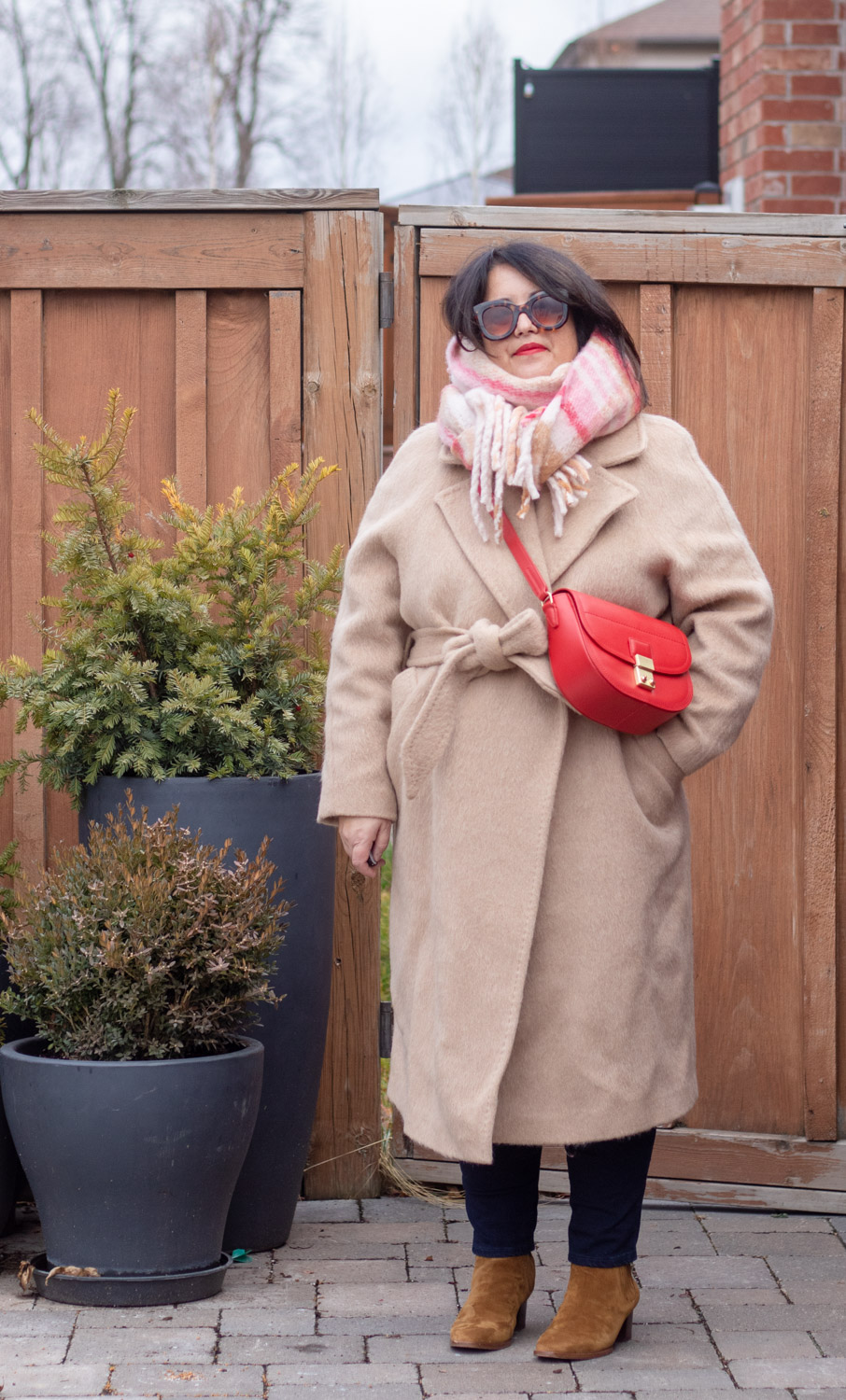 fuzzy camel coat, red bag, soft plaid scarf