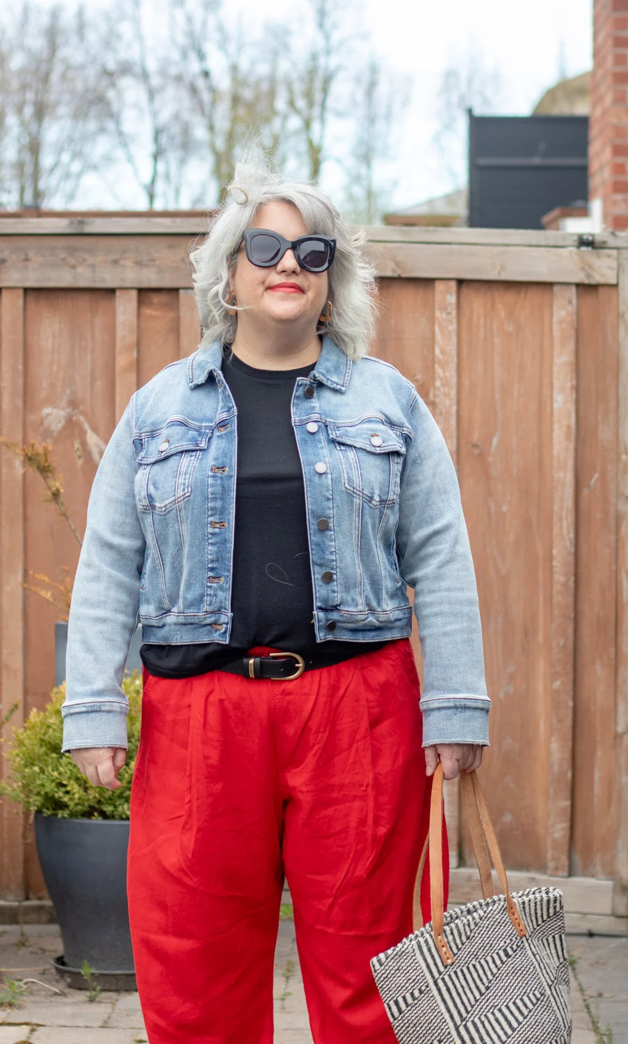 red linen outfit with black tee and jean jacket